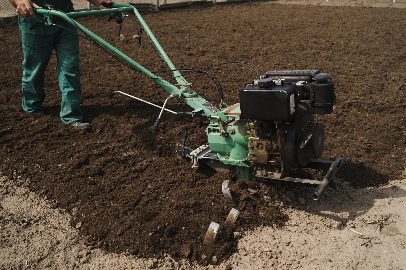 Man plowing the land in the garden on sky background